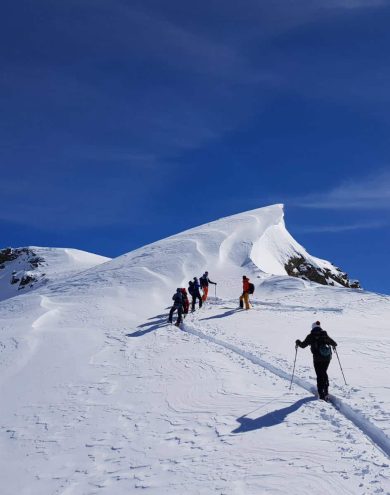 Belle-randonnee-de-groupe-en-haute-montagne-avec-neige-fraiche-et-soleil.jpeg